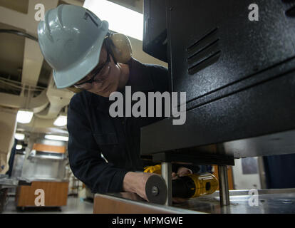 170330-N-VB241-054 Bremerton, Washington (30 mars 2017) Technicien d'entretien des coques de pompier Devin Hollman, Brocton, New York, meule de soudure vers le bas sur une machine à café avant de souder en place sur le ponts mess à bord de l'USS JOHN C. STENNIS (CVN 74). John C. Stennis mène une disponibilité progressive prévue (PIA) au chantier naval de Puget Sound et l'Installation de maintenance de niveau intermédiaire, au cours de laquelle le navire est soumis à des activités de maintenance et de mise à niveau. (U.S. Photo par marine Spécialiste de la communication de masse de la classe 3ème Zachary C. Wolfe / relâché) Banque D'Images