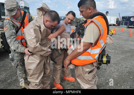 Gardien de la Géorgie, les centres de Perry, Géorgie, 30 mars 2017 - Des soldats de la défense chimique, biologique, radiologique et nucléaire de l'élément de soutien de l'aide aider les uns les autres s'habillent dans leurs costumes de manipulation matérielle de danger. Un segment d'affaire vint dans l'assistant à la Garde nationale du Kentucky dans leurs opérations pendant la garde vigilante 17. 17 garde vigilante est un exercice visant à promouvoir l'interopérabilité inter-organismes dans quatre régions. (U.S. Photo de la Garde nationale par la CPS. Kiara sueur/libéré) Banque D'Images