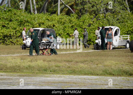 L'équipage de la Garde côtière canadienne d'aider le personnel des services d'urgence locaux dans le transport d'un patient à Queens Medical Centre à partir de la Coast Guard Air Station barbiers Point, Oahu, le 4 avril 2017. Le 74-year-old man est arrivé dans un état stable à Honolulu après avoir été évacué par un HC-130 Hercules avion à voilure fixe 1 061 miles de Atoll de Palmyra. (U.S. Photo de la Garde côtière canadienne par le maître de 3e classe Amanda Levasseur/libérés) Banque D'Images