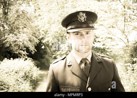 Bel officier de l'armée américaine WWII GI en uniforme à travers les bois Banque D'Images