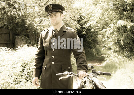 Bel officier de l'armée américaine WWII GI en uniforme à la maison avec son vélo Banque D'Images