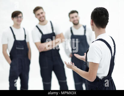 L'équipe de déménageurs joyeuse responsable et leur chef souriant. Banque D'Images