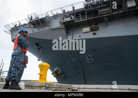 170406-N-XT039-110 Okinawa, Japon (6 avril 2017) Maître de Manœuvre 3 Classe Tajh Parkins, à l'avant, de Louisville, Ky., affectés à des activités de la flotte, commandant de l'Okinawa (OAFC) opérations portuaires, et spécialiste en logistique Seaman Angel Acevedo, de San Juan, Porto Rico, affecté à la station de transport amphibie USS Green Bay (LPD 20), effectuer la manipulation de fonctions que le navire d'assaut amphibie USS Bonhomme Richard (DG 6) arrive à White Beach pierside installation navale de débarquer les Marines de la 31e Marine Expeditionary Unit. Bonhomme Richard, navire amiral du Bonhomme Richard Gro Amphibie Banque D'Images