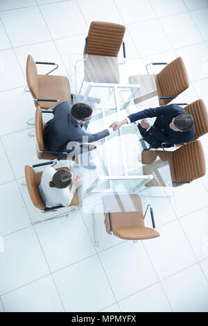 Poignée de l'autre côté de la table. Rencontre autour d'une table de conférence. Banque D'Images