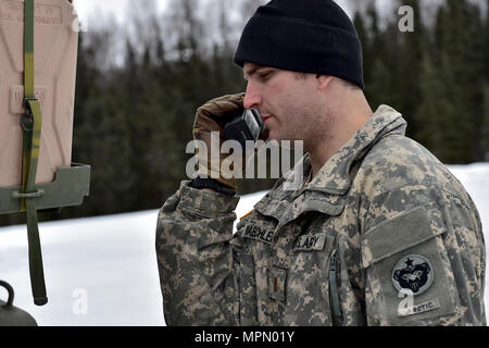 Lieutenant de l'Armée de Jacob Maechler, originaire de Mena, Ark., affecté à la 95e compagnie de produits chimiques, de l'Arctique "dragons", 17e Bataillon de soutien au maintien en puissance de combat de l'armée américaine, l'Alaska fait une radio (avant un exercice de tir réel de tir avec M1135 Stryker Véhicules de reconnaissance nucléaire, biologique et chimique sur Joint Base Elmendorf-Richardson, Alaska, le 5 avril 2017. L'épreuve de tir à l'identification des compétences du soldat, engagement, et d'éliminer des cibles hostiles tout en augmentant l'efficacité au combat. Le NBCRV Styker fournit des armes nucléaires, biologiques et chimiques pour le champ de bataille de détection et surveillance Banque D'Images