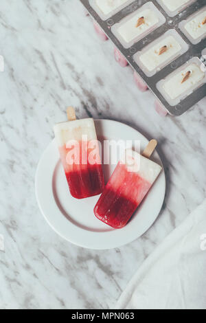 Des sucettes glacées au yogourt et aux fraises Banque D'Images
