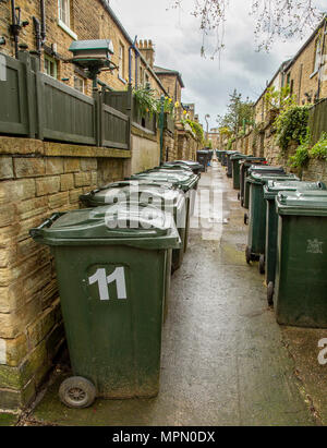 Rangées de bacs verts wheelie line les ruelles entre les maisons en terrasse Saltaire, Yorkshire. Banque D'Images