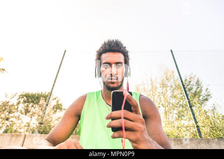 Basket-ball player l'music, smartphone et écouteurs Banque D'Images