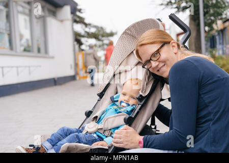 Allemagne, Timmendorfer Strand, mère à côté de son soleil en buggy Banque D'Images