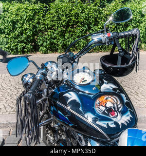 Berlin Mitte, moto détail. Vélo parqué avec tiger face, noir en cuir et casque tassles Bikers au démo. Banque D'Images