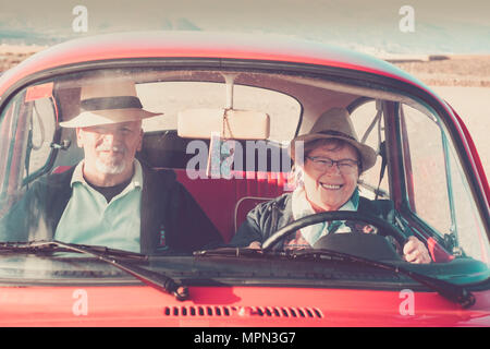 Couple de retraités et d'avoir du plaisir de conduite avec une vieille voiture vintage Banque D'Images