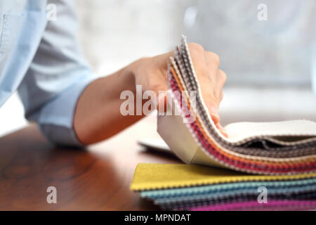 Les tissus de recouvrement . La femme regarde les couleurs et les motifs des tissus d'ameublement. Banque D'Images