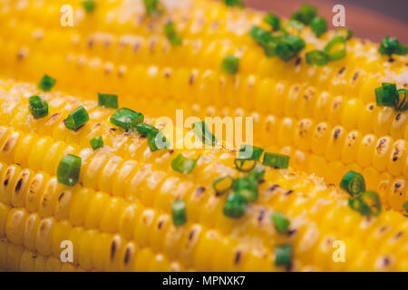 Les épis de maïs au barbecue avec des herbes sur une table en bois Banque D'Images