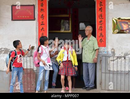 (180524) -- NANCHANG, 24 mai 2018 (Xinhua) -- les enfants à des adieux Yanxiang Miao la station de soins pour enfants à gauche derrière dans sa maison à Shibu Ville, Ville de Nanchang Jiangxi Province de Chine orientale, le 23 mai 2018. Miao, de plus de 70 ans, a créé une station de soins pour enfants à gauche derrière sa propre maison en 2009, où il a fourni gratuitement pour les enfants à faire leurs devoirs et d'étude après l'école. Ayant reçu plus de 3 000 enfants au cours des neuf dernières années, Miao est satisfait de son travail bénévole en tant que il voir les progrès des enfants. (Xinhua/Peng Zhaozhi) (zwx) Banque D'Images