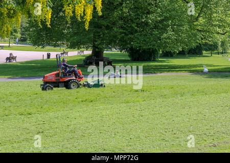 Lurgan, Irlande du Nord. 24 mai 2018. Royaume-uni - un autre très chaude journée ensoleillé à Lurgan. Un homme coupé de l'herbe à Lurgan Park tout autres personnes vous détendre sur une bonne journée chaude. Crédit : David Hunter/Alamy Live News. Banque D'Images