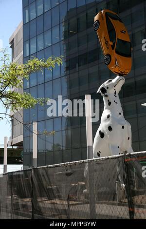 New York, New York, USA. 24 mai, 2018. Planeur à une hauteur d'un immeuble de trois étages, a 38-foot-tall statue d'un dalmatien, parfaitement l'équilibre entre un taxi jaune sur le nez, se trouve à l'extérieur de l'hôpital du site de construction. Le taxi est un véritable Prius, offert par Toyota, qui a été dépouillé de son moteur, et quand il pleut, les essuie-glaces s'active, selon l'hôpital NYU Langone. Credit : Ronald G. Lopez/ZUMA/Alamy Fil Live News Banque D'Images