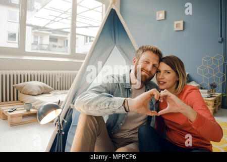 Happy couple at home camping ina tente dans le salon Banque D'Images