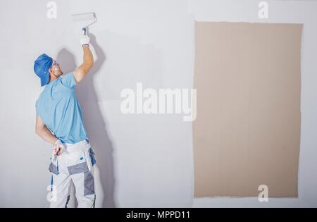 Prix peintre au travail. La peinture plus foncée couvrant par un plus léger et frais. Rénovation appartement. Les murs rafraîchissante. Thème de la construction. Banque D'Images