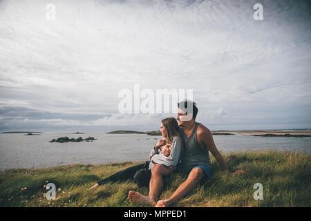 France, Bretagne, Landeda, les Dunes de Sainte-Marguerite, young couple sitting at the coast Banque D'Images