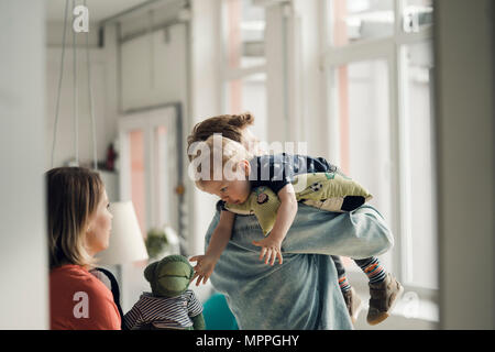 Famille heureuse de jouer avec leur fils à la maison Banque D'Images