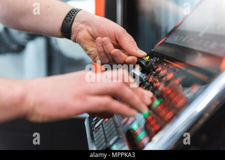 Close-up de l'homme d'utiliser la machine en usine Banque D'Images