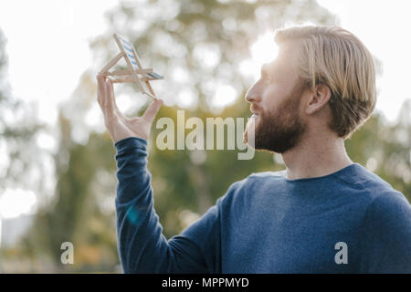 L'homme dans le parc automne à la plage miniature à rêver d'été, chaises longues Banque D'Images