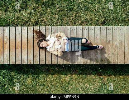 Vue de dessus d'une jeune femme couchée sur boardwalk Banque D'Images