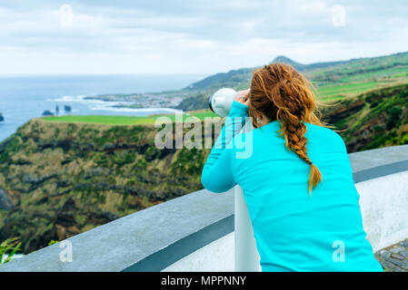 Sao Miguel, Açores, à la femme à travers un jumelles touristiques vers la mer Banque D'Images
