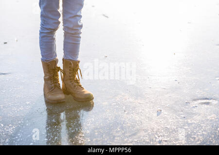 Allemagne, Brandebourg, lac Straussee, les pieds avec des bottes sur lac gelé Banque D'Images