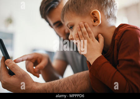 Père et petit fils avec smartphone Banque D'Images