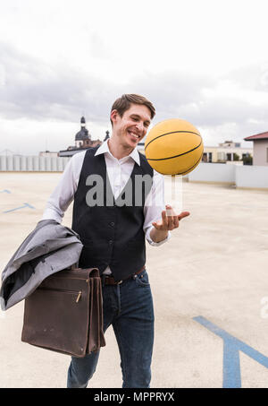 Portrait avec le basket-ball marche à un garage de stationnement Banque D'Images