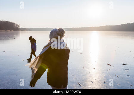 Allemagne, Brandebourg, lac Straussee, deux enfants de marcher sur un lac gelé Banque D'Images