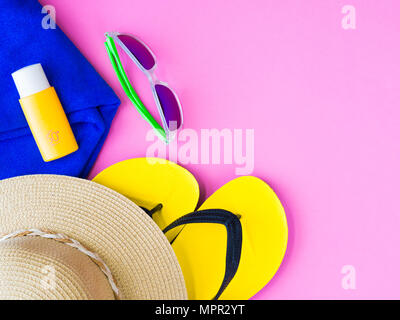 Les lunettes de l'été avec chapeau, tongs, serviette bleu et un écran solaire sur fond rose.Locations et voyage d'été, détente concept. Banque D'Images