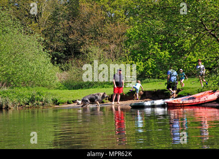 Une famille s'amusant par la rivière Bure sur les Norfolk Broads près de Wroxham, Norfolk, Angleterre, Royaume-Uni, Europe. Banque D'Images