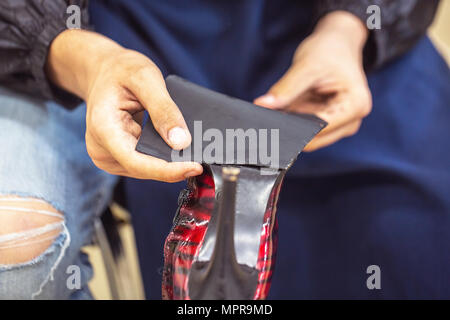 Close-up d'un jeune homme en jeans travailleur les broches la plante Banque D'Images