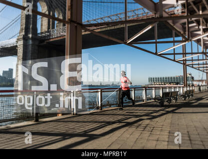 USA, New York City, l'homme qui court à l'East River avec des données issues de smartwatch Banque D'Images