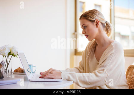 Woman using laptop at home Banque D'Images