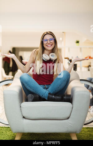 Happy casual young woman sitting in armchair en espace de coworking Banque D'Images