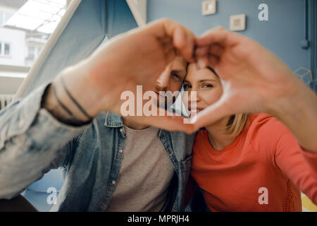 Happy couple at home camping ina tente dans le salon Banque D'Images