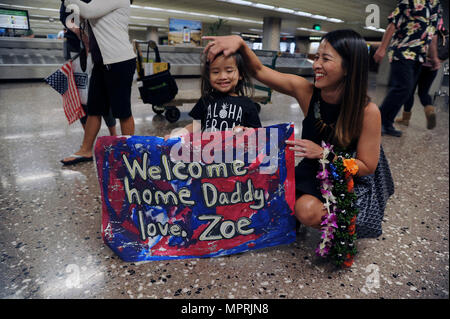 Arcayan la joie et sa fille de trois ans, Zoe, attendre impatiemment leur aviateur, Tech. Le Sgt. Anthony, Arcayan d'Honolulu, Hawaii, un membre de la Réserve aérienne aérienne escadron du 48e de Port, à revenir d'un déploiement de six mois à l'Aéroport International d'Honolulu, Honolulu, le 11 avril 2017. Arcayan et six autres ont apporté le 8e Escadron à la mobilité aérienne expéditionnaire Al Udeid Air Base, au Qatar, en fournissant leur expertise dans tous les domaines de l'air terminal operations pour inclure chargement de l'aéronef, l'inspection et de traitement du fret, services aux passagers et les services de la flotte d'aéronefs. Banque D'Images