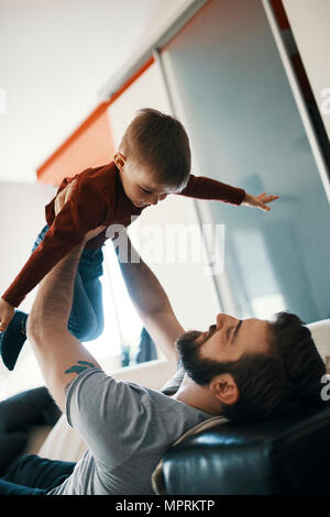 Père et petit fils jouer ensemble à la maison Banque D'Images