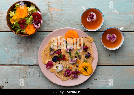 Pancake avec fleurs comestibles, fleurs de courge, de Calendula, Chamaemelum nobile, Dianthus, Taraxacum officinale, alto, Rosmarinus officinalis sur bambou pl Banque D'Images