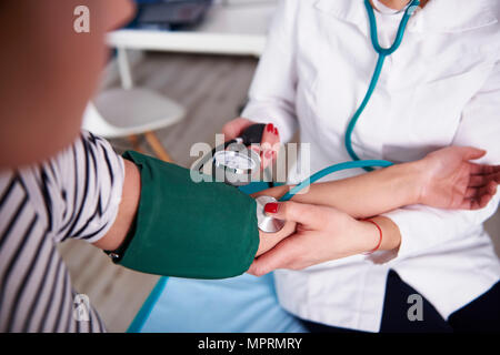 Médecin de prendre la tension artérielle de la femme dans la pratique médicale Banque D'Images