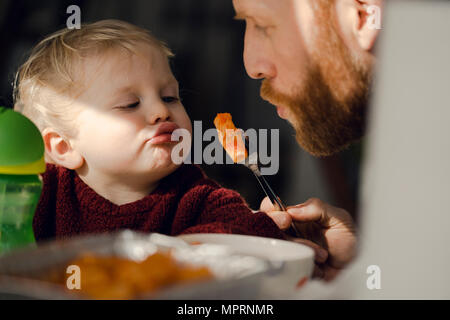 Alimentation père son petit-fils avec des pâtes Banque D'Images