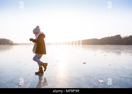 Allemagne, Brandebourg, lac Straussee, fille qui marche sur le lac gelé Banque D'Images