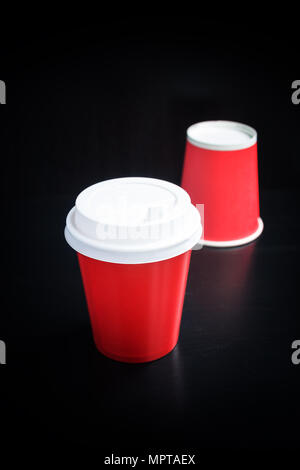 Tasses de café rouge sur fond noir. Café à emporter Banque D'Images