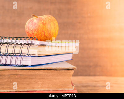 Concept Retour à l'école. Style rétro d'Apple sur des piles de livres sur fond de table en bois. Banque D'Images