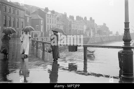 Un jour de pluie sur Pier Road, Whitby, North Yorkshire, 1896-1920. Artiste : Alfred Newton & Sons. Banque D'Images