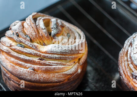 Gâteau Cupcake crunch sous la forme d'un rouleau saupoudré de sucre en poudre sur un fond sombre et un ancien auvent. Pâques et Noël cuisson. Haut de page vi Banque D'Images