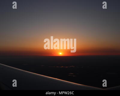 Coucher du soleil à l'Aéroport International JFK à travers la fenêtre de l'avion signifie la fin du voyage et en même temps le début de la meilleure Banque D'Images